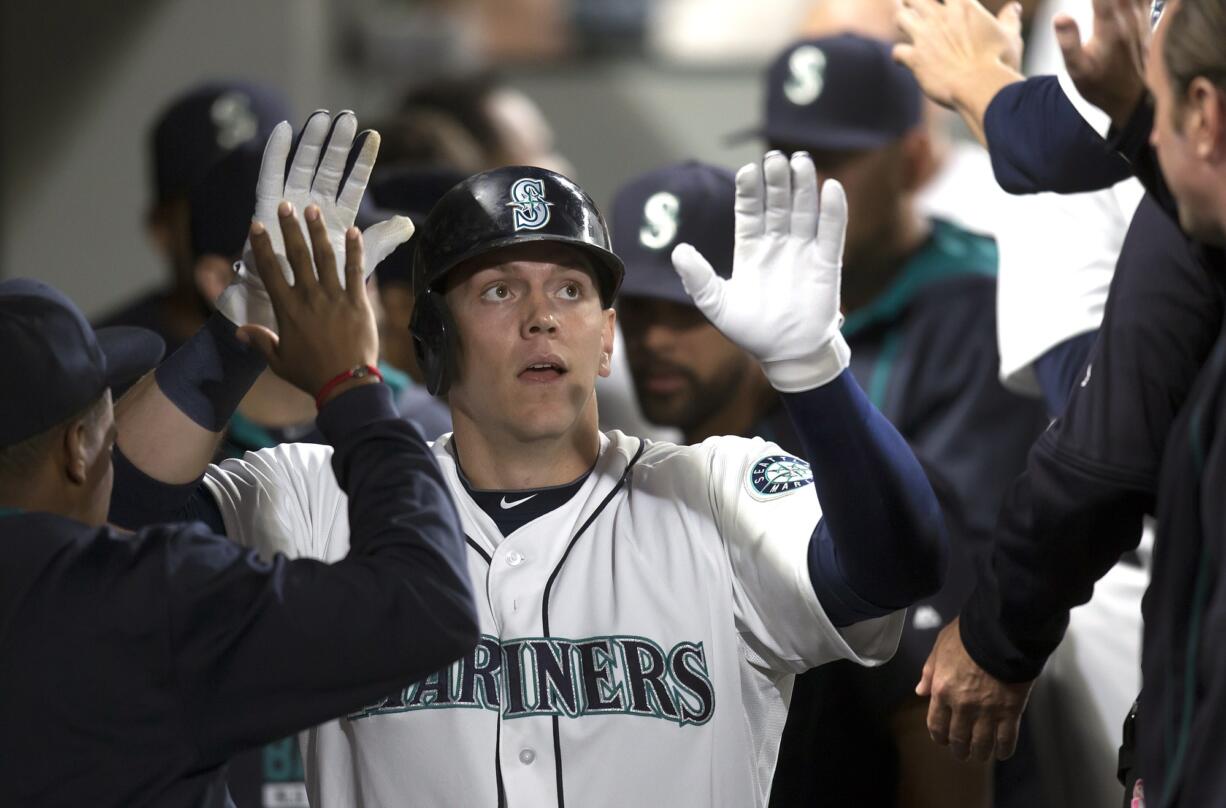 Seattle Mariners Logan Morrison is congratulated by teammates after hitting a two-run home run during the fourth inning of a baseball game against the Oakland Athletics, Tuesday, Aug. 25, 2015, in Seattle. The Mariners won 6-5.