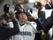 Seattle Mariners Logan Morrison is congratulated by teammates after hitting a two-run home run during the fourth inning of a baseball game against the Oakland Athletics, Tuesday, Aug. 25, 2015, in Seattle. The Mariners won 6-5.