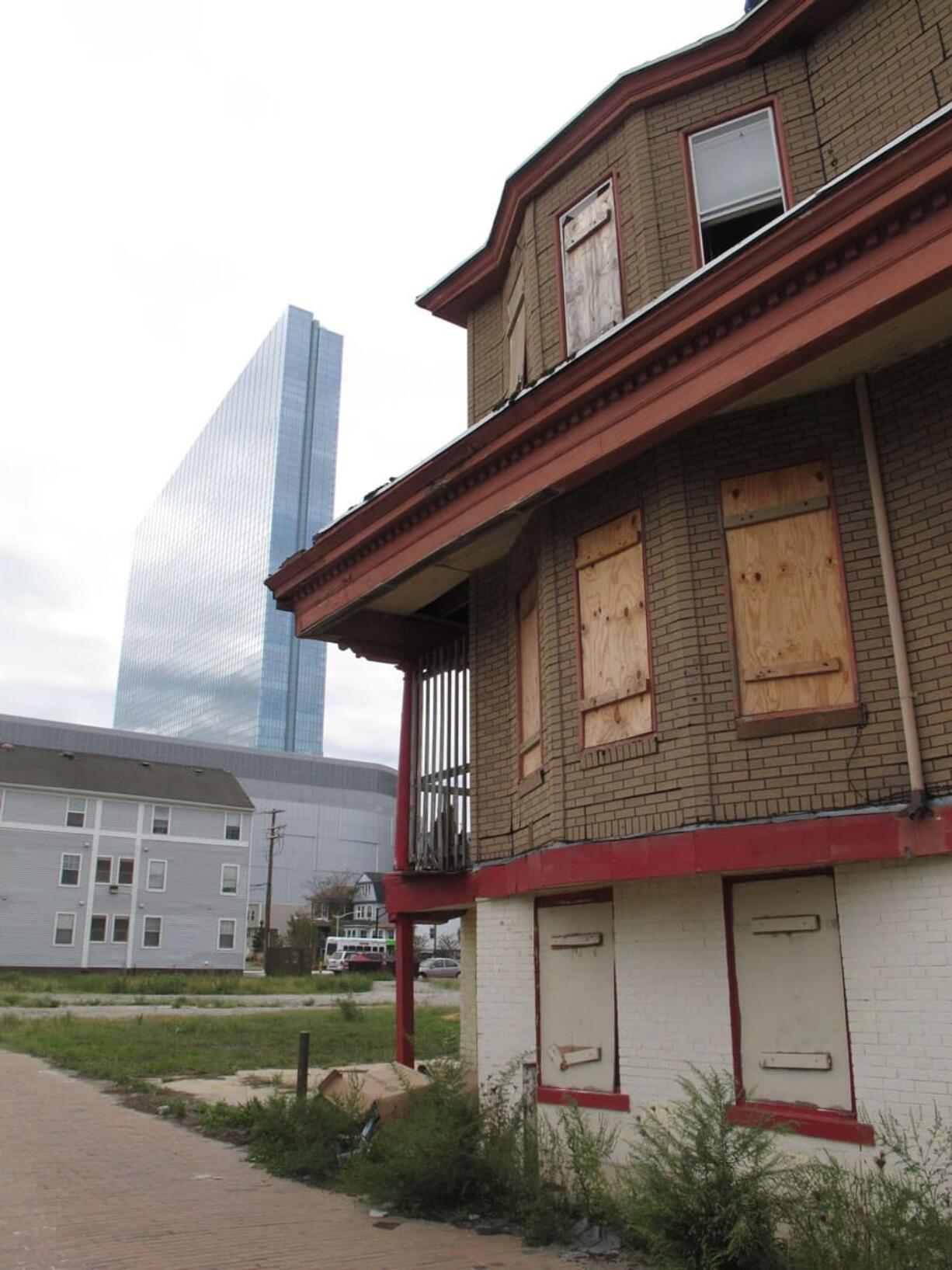 Associated Press files
A vacant boarded-up building in September 2012 is in the shadow of the brand new Revel Casino Hotel in Atlantic City, N.J., which had opened six months earlier. Revel is one of three casinos there that could close by September.