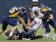 Union quarterback Tanner Nelson is stopped by Bellevue's Matt Gilbert, left, and William Bissell, #36,