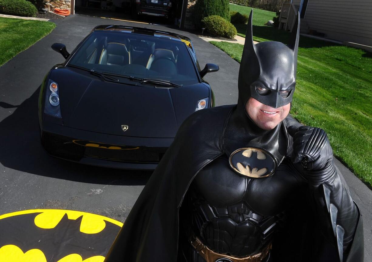 Leonard Robinson, dressed as Batman, poses for a photo outside his home, in Owings Mills, Md.