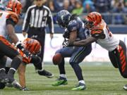 Seattle Seahawks' Marshawn Lynch (24) has the ball stripped by Cincinnati Bengals' Dontay Moch during the first half Sunday.