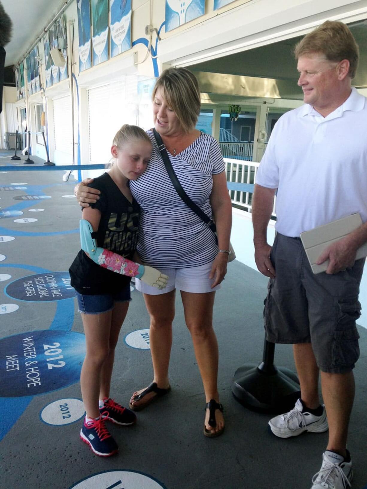 Annika Emmert, a 10-year-old who was born without her right arm, stands with her mother, Karon Emmert, on Thursday at the Clearwater Marine Aquarium in Clearwater, Fla.