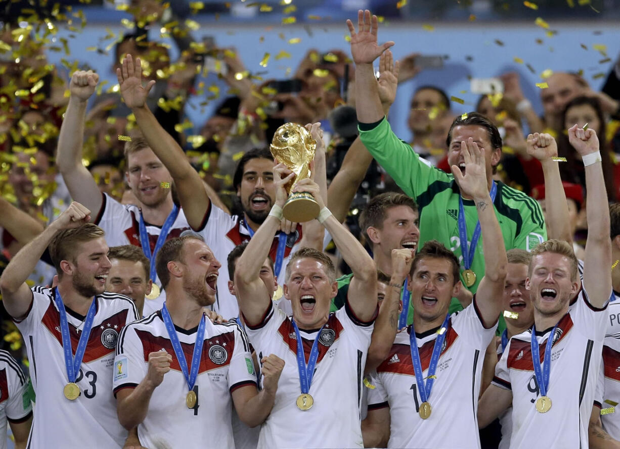 Germany's Bastian Schweinsteiger holds up the World Cup trophy following their 1-0 victory over Argentina after the World Cup final soccer match between Germany and Argentina at the Maracana Stadium in Rio de Janeiro, Brazil, Sunday, July 13, 2014.