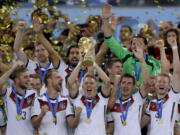 Germany's Bastian Schweinsteiger holds up the World Cup trophy following their 1-0 victory over Argentina after the World Cup final soccer match between Germany and Argentina at the Maracana Stadium in Rio de Janeiro, Brazil, Sunday, July 13, 2014.