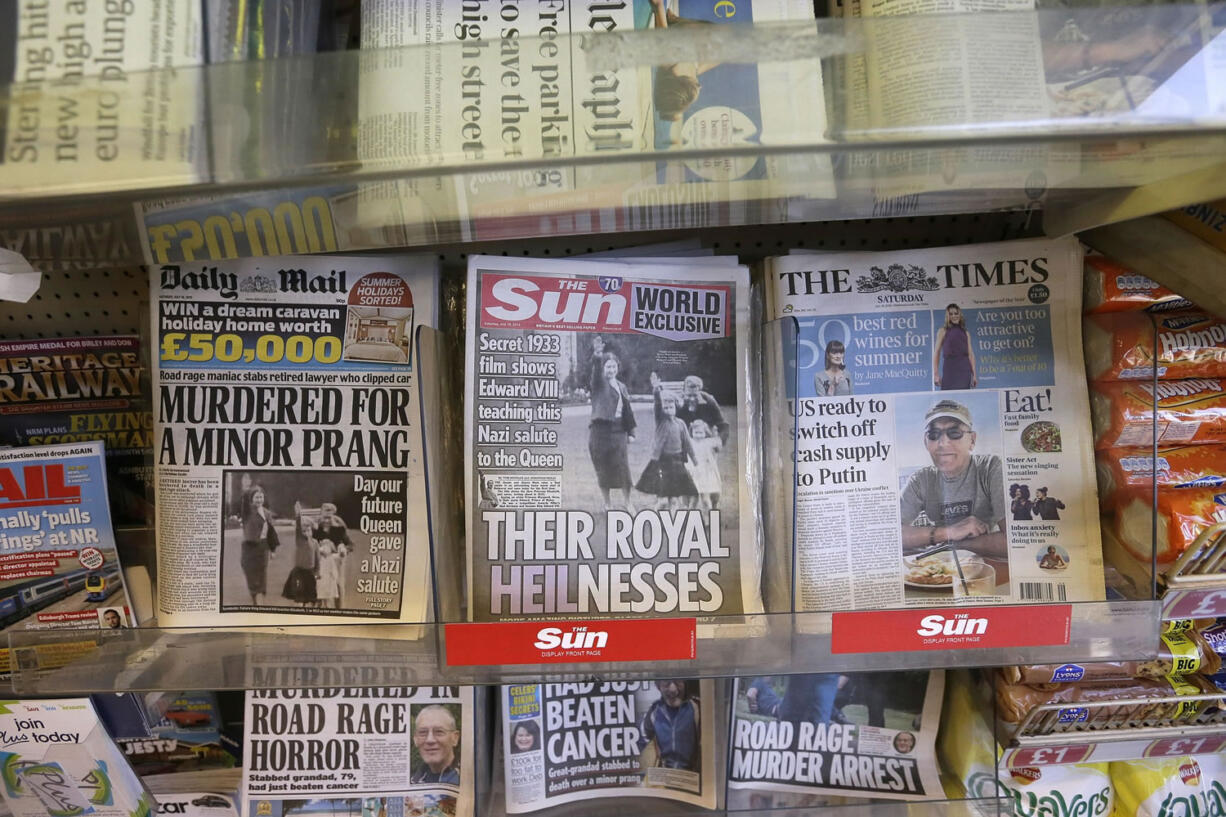 A row of newspapers on display including a paper with a photo of Britain's Queen Elizabeth as a child giving a Nazi salute,  in a shop, in London, Saturday.