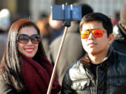 Tourists use a 'selfie stick' in London.