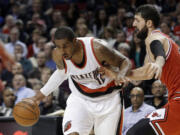 Portland Trail Blazers forward LaMarcus Aldridge, left, drives on Chicago Bulls forward Nikola Mirotic during the second half of an NBA basketball game  in Portland, Ore., Friday, Nov. 21, 2014.  Aldridge scored 16 points as the Trail Blazers defeated the Bulls 105-87.