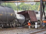 An investigator photographs the scene where a locomotive and cars carrying crude oil went off the track beneath the Magnolia Bridge in the Interbay neighborhood of Seattle on Thursday morning.