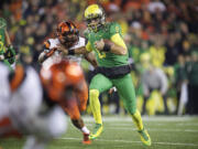 Oregon quarterback Marcus Mariota (8) breaks away from Oregon State defender Jabral Johnson (44) for a touchdown during the second quarter Saturday in Corvallis, Ore.