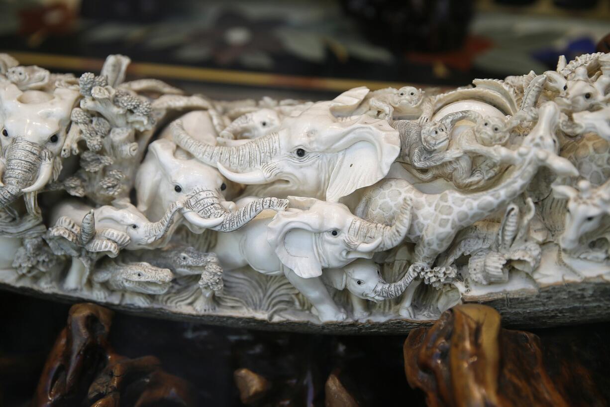 Carvings of elephants and other animals are shown inside a mammoth ivory tusk for sale in the window of a Chinatown shop in San Francisco.