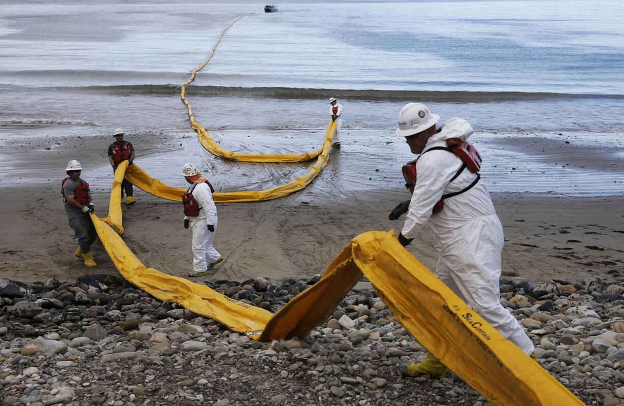 Workers prepare an oil containment boom May 21 at Refugio State Beach, north of Goleta, Calif.