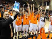 Oregon State head coach Scott Rueck hoists the Pac 12 Championship trophy while celebrating after the Beavers defeated California 73-55 at Gill Coliseum in Corvallis, Ore. on Saturday, Feb. 28, 2015.