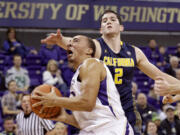 Washington's Andrew Andrews drives to the basket past California's Sam Singer in the first half on Sunday, Feb. 1, 2015, in Seattle.