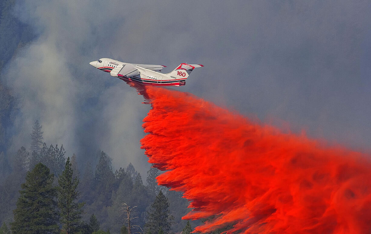 A firefighting aircraft Thursday drops retardant over a wildfire along a hillside near Foresthill, Calif. Fire crews are making steady progress against a wildfire burning near a Northern California interstate that has destroyed six homes and is threatening hundreds more. State fire officials say the blaze along Interstate 80 about 40 miles northeast of Sacramento was holding steady at 420 acres on Friday while containment increased to 30 percent.