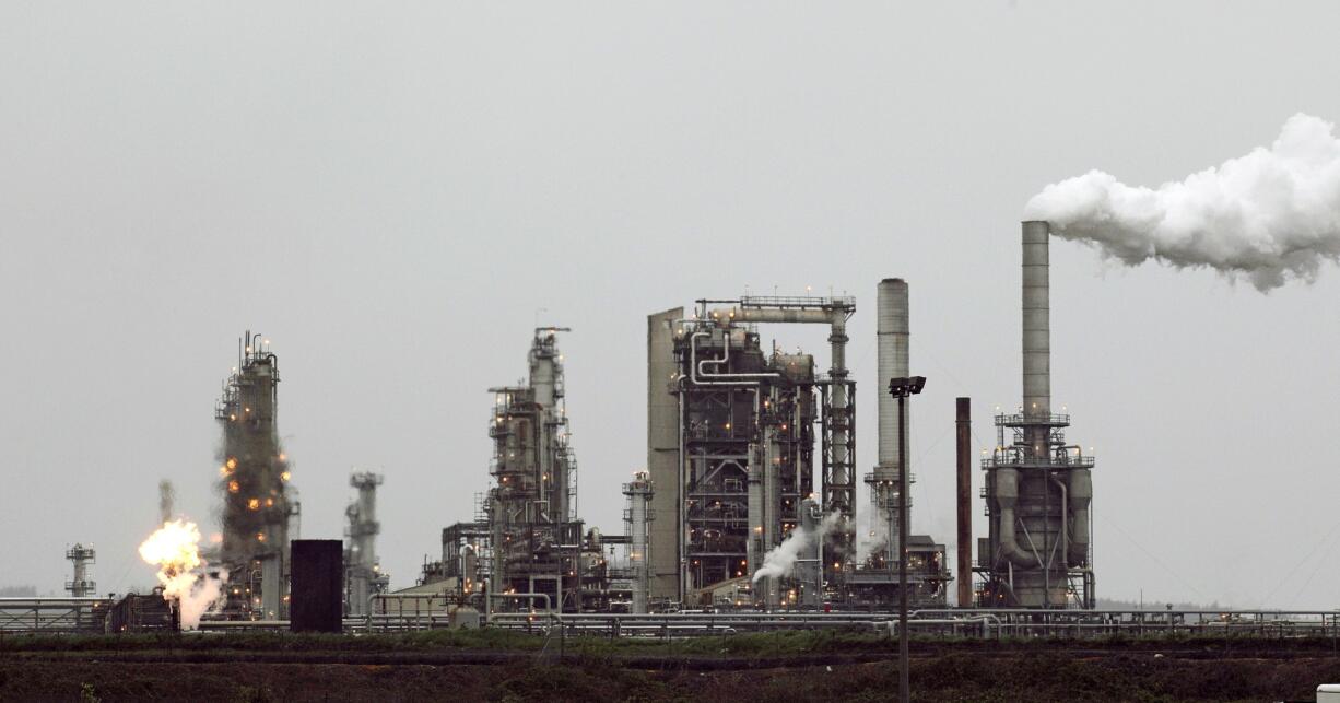 Associated Press files
A Tesoro Corp. refinery in Anacortes, including a gas flare flame that is part of normal plant operations, is among those likely to be affected by Gov. Jay Inslee's sweeping proposal to rein in greenhouse gases.