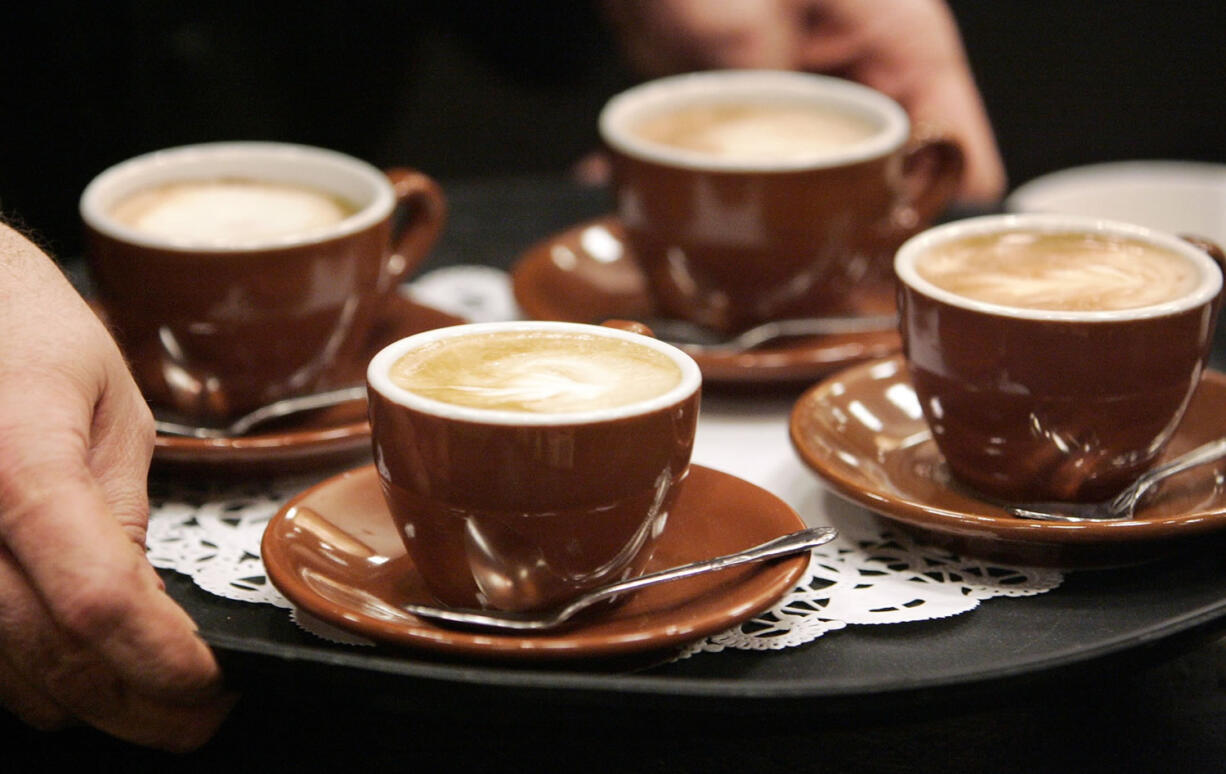 The owner of a coffee shop serves cappuccinos to judges during a barista competition in Cranberry, Pa.