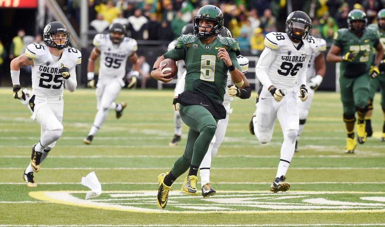 Oregon quarterback Marcus Mariota (8) runs for a touchdown during the first quarter against the Colorado on Saturday, Nov. 22, 2014, in Eugene, Ore.