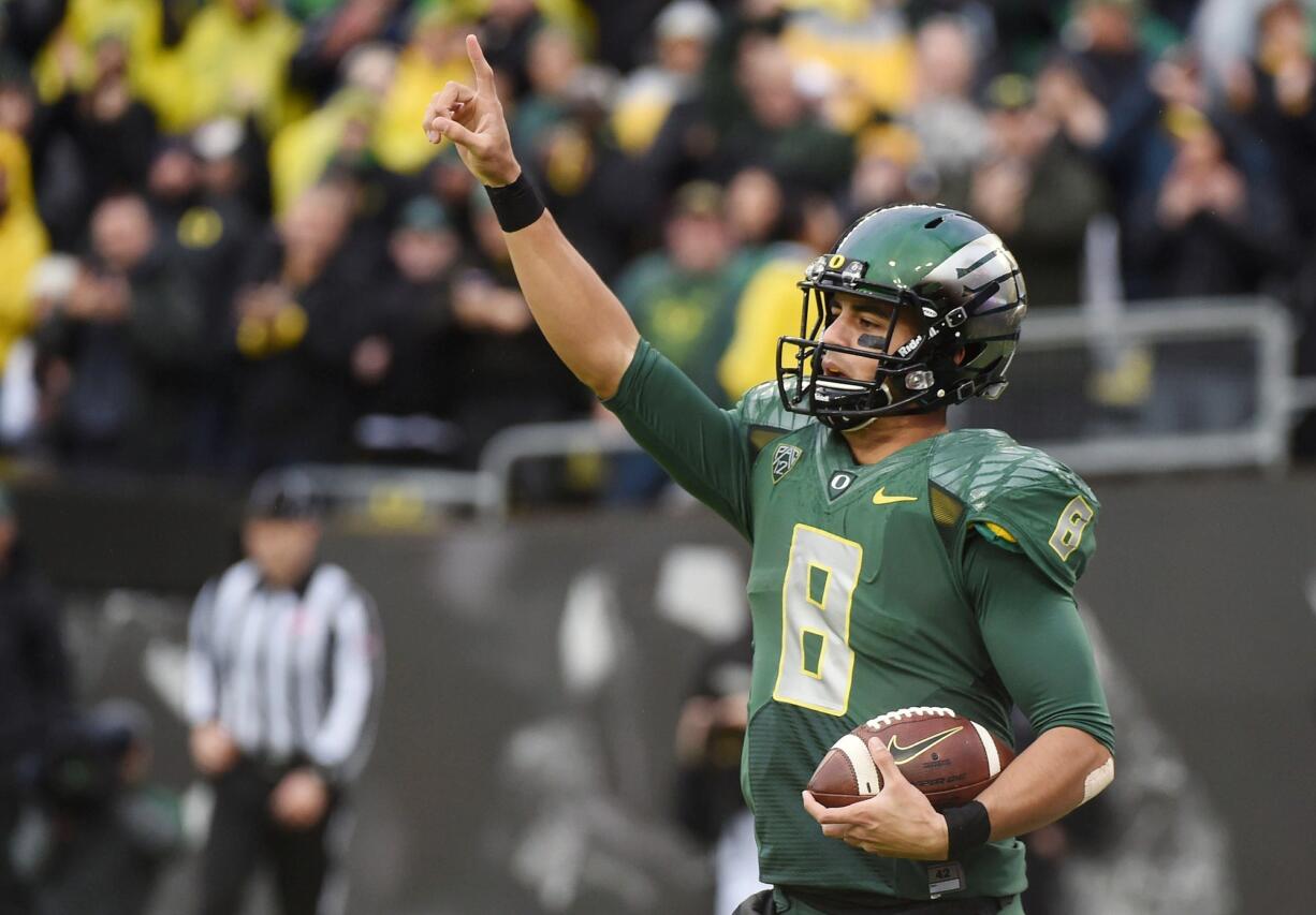 Oregon quarterback Marcus Mariota (8) celebrates after scoring a touchdown during the first quarter of an NCAA college football game against the Colorado on Saturday, Nov. 22, 2014, in Eugene, Ore.