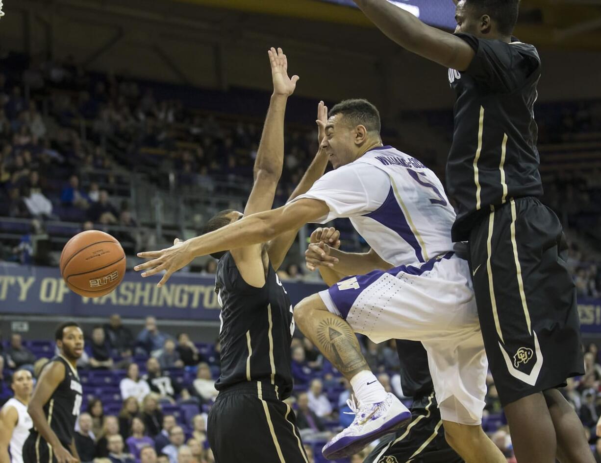 Washington's Nigel Williams-Goss, center, passes in traffic as Colorado's Xavier Talton, left, and Wesley Gordon defend during the first half Thursday, March 5, 2015, in Seattle.