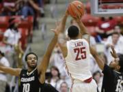 Washington State guard DaVonte' Lacy (25) shoots over Colorado guards Tre'Shaun Fletcher (10) and Dominique Collier (15) during the first half Saturday, March 7, 2015, in Pullman.