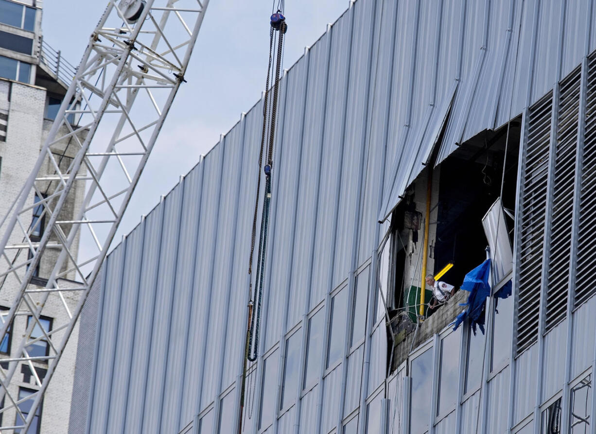 A New York City Fire Department official peers from an opening Sunday near the top of 261 Madison Ave.