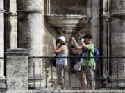 Tourists shoot pictures outside the Cathedral in Old Havana, Cuba.