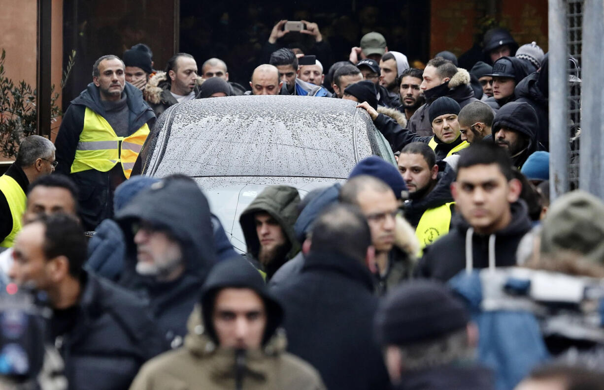 The car containing the body of Omar Abdel Hamid El-Hussein, the man accused of the two shootings which led to two civilians dead last weekend in Copenhagen, is escorted from the Islamic Society's building in Copenhagen on Friday.