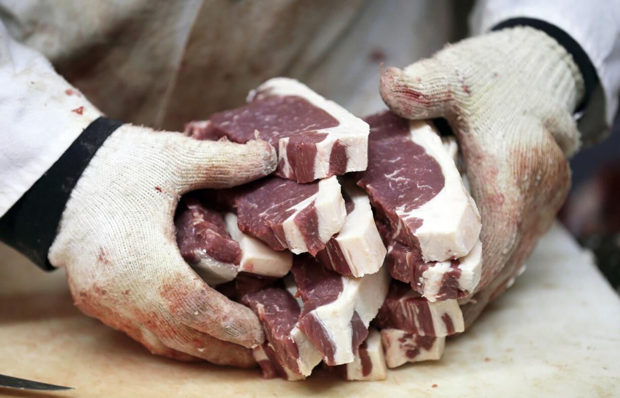 Amend Packing Company owner Kent Weise holds freshly cut New York strip steaks in Des Moines, Iowa.