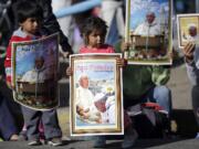 Children holding posters wait for the arrival of Pope Francis at the Sanctuary of El Quinche, in El Quinche, Ecuador, on Wednesday.