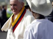 Pope Francis is welcomed by children in traditional costumes on his arrival Sunday to the Mariscal Sucre International Airport in Quito, Ecuador.