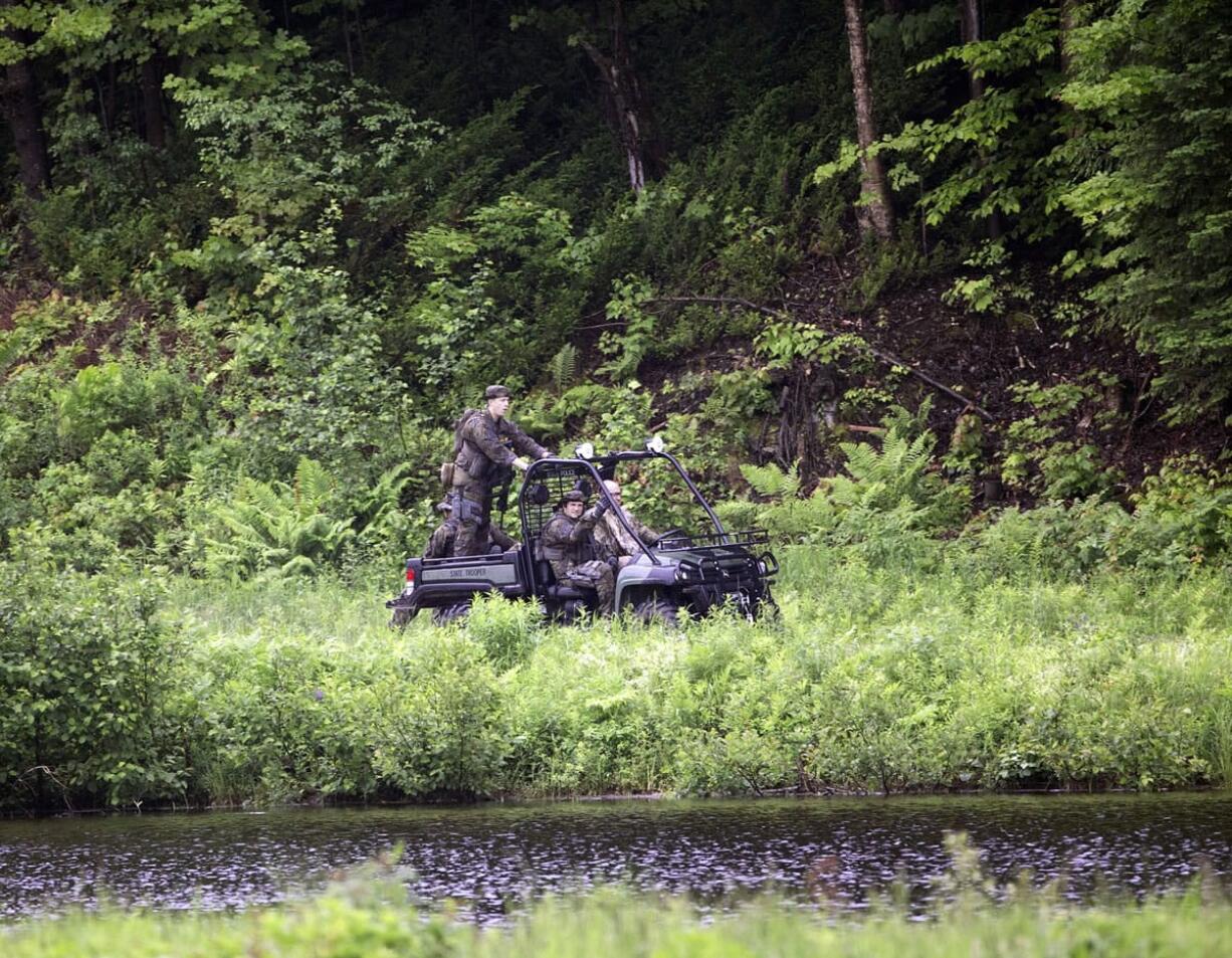 Law enforcement officers ride an an all-terrain vehicle along Studley Hill Road after searching the area for two prison escapees from Clinton Correctional Facility in Dannemora, on Tuesday in Malone, N.Y.