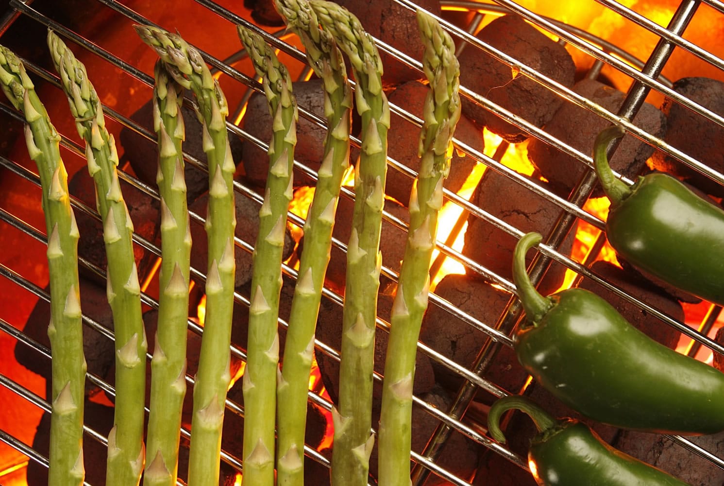 Make room on your barbecue for appetizers such as these grilled asparagus and jalapeno peppers.