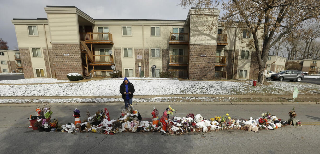 Shonta Johnson of Chicago takes photos Monday of a memorial in the middle of the street in Ferguson, Mo., where Michael Brown was shot and killed by a policeman more than three months ago.