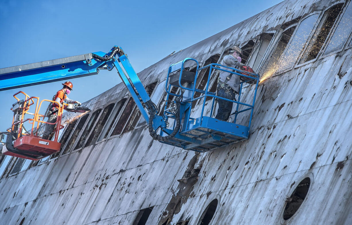 Chad Campos, left, and Jason Jacobson use metal cutting wheels as they sawed out individual windows of the Kalakala as demolition continued on the iconic ferry at the Concrete Technology Corp.