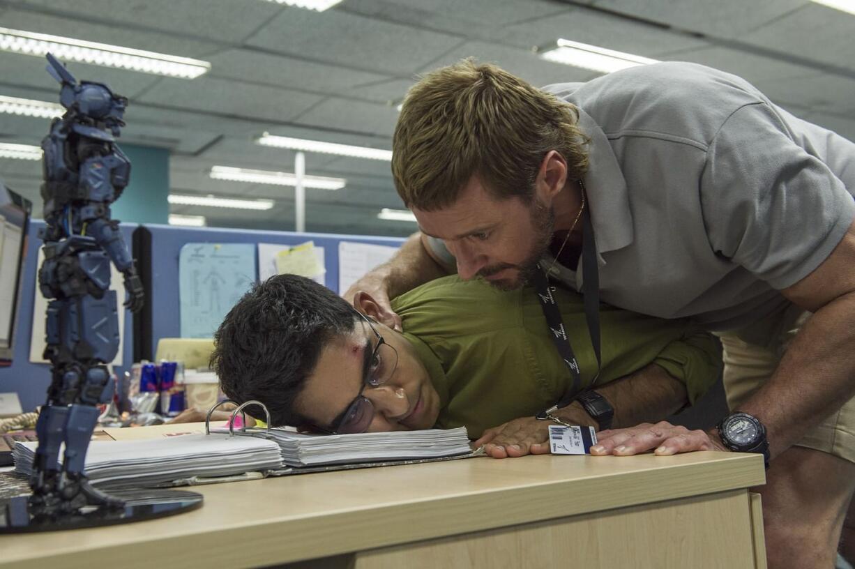 Columbia Pictures
Hugh Jackman, right, threatens Dev Patel in &quot;Chappie.&quot;