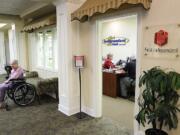 First Independent personal banker Karen Meisner, wearing red, helps Ellery Bennett at the bank's small branch at Touchmark at Fairway Village senior living community.