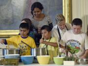 First lady Michelle Obama watches as school children as prepare lunch in the East Room of the White House in October following the annual fall harvest of the White House Kitchen Garden in Washington.