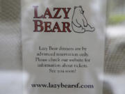 A sign in the front window explains how to purchase tickets to dine at the Lazy Bear restaurant in San Francisco.