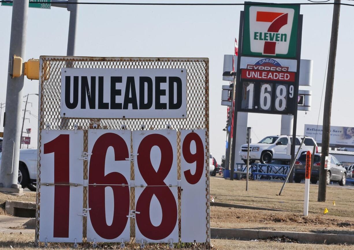 Signs at two gas stations advertise unleaded gasoline for $1.68, in Oklahoma City on Friday. For the first time since 2009, most Americans are paying less than $2 a gallon.