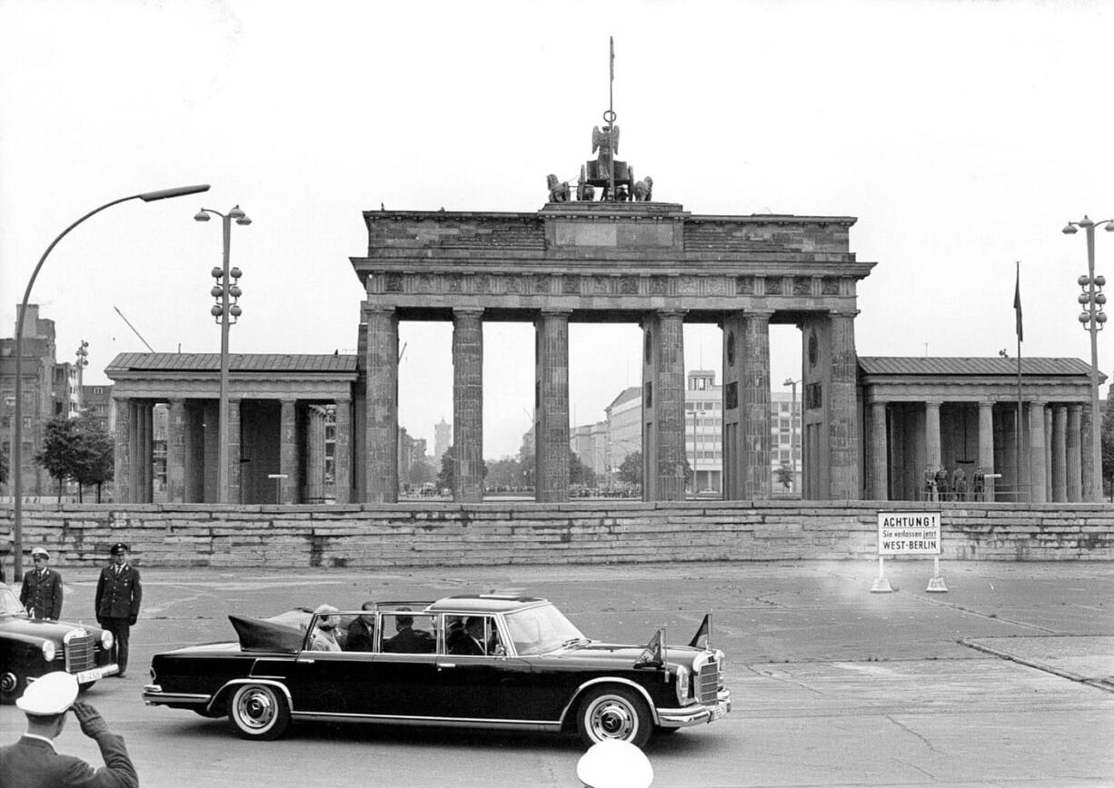 A May 27, 1965, photo of Britain's Queen Elizabeth II and Prince Philip being driven in a Mercedes 600 car as they pass the Brandenburg Gate during their first visit to Berlin.