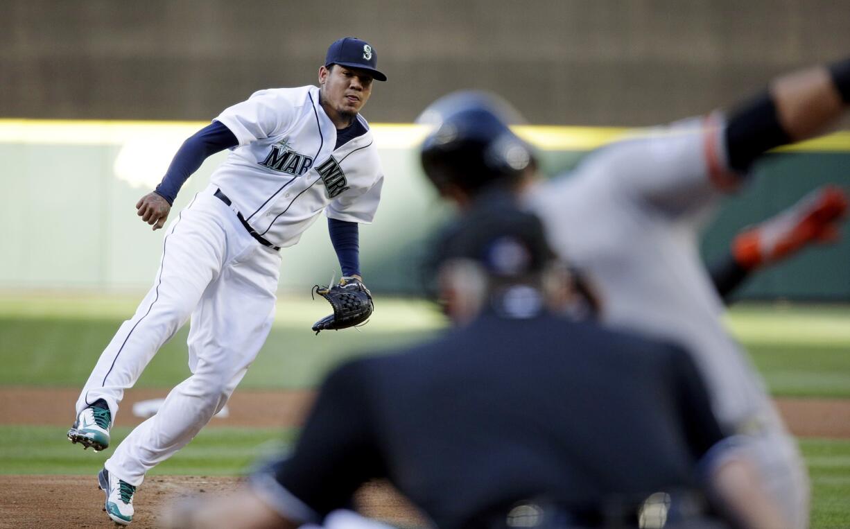 Seattle Mariners starting pitcher Felix Hernandez, left, watches as San Francisco Giants' Joe Panik swings and misses to strike out during the first inning Wednesday, June 17, 2015, in Seattle.