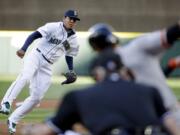 Seattle Mariners starting pitcher Felix Hernandez, left, watches as San Francisco Giants' Joe Panik swings and misses to strike out during the first inning Wednesday, June 17, 2015, in Seattle.