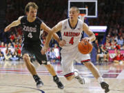 Arizona guard T.J. McConnell, right, drives to the net against Gonzaga guard Kevin Pangos during the first half Saturday, Dec. 6, 2014, in Tucson, Ariz.