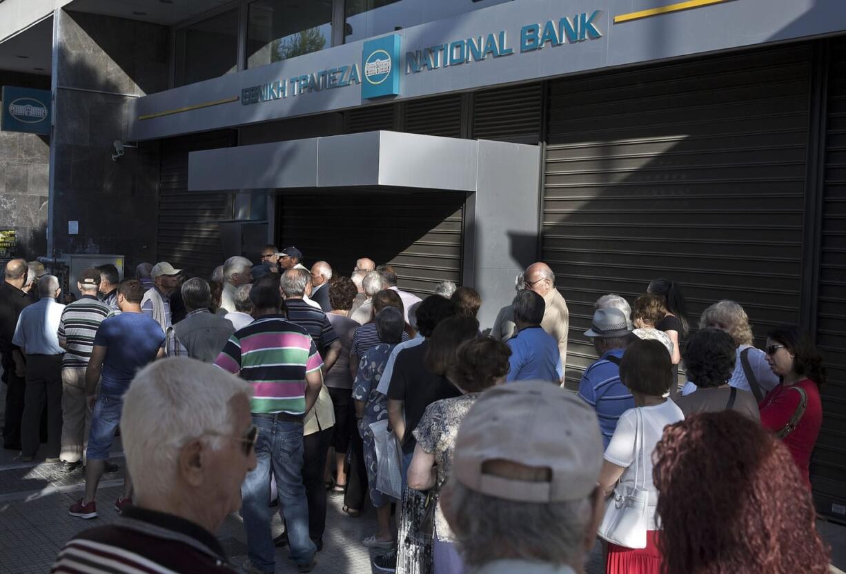 Elderly people, who usually get their pensions at the end of the month, wait Monday outside a closed bank in Athens.