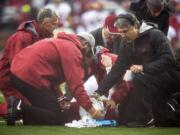 Washington State head coach Mike Leach comforts quarterback Connor Halliday, center, as team physicians and trainers attend him during the first quarter of an NCAA college football game Saturday, Nov. 1, 2014, at Martin Stadium in Pullman. Leach said Monday that Halliday suffered a broken ankle, ending his college career.