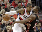 Portland Trail Blazers forward LaMarcus Aldridge, left, drives against Miami Heat center Chris Bosh during the first half in Portland on Thursday, Jan. 8, 2015.