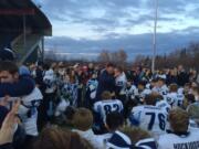 Hockinson's Austen Johnson (33) is hugged by coach Rick Steele following the Hawks' 52-28 season-ending loss to Lynden on Saturday at Civic Stadium in Bellingham.