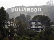 Homes sit on the hillside near the Hollywood Sign, Tuesday, Jan. 20, 2015, in Los Angeles. Hollywood Sign Seekers can't just take a bus or join a tour group to get there. Arriving at the landmark sign that towers magnificently over Los Angeles' skyline requires traipsing through a densely populated hillside neighborhood of 20,000 people and numerous multimillion-dollar homes located on steep, narrow, almost impassable streets. (AP Photo/Jae C.