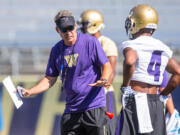 University of Washington head coach Chris Petersen coaches wide receiver Jaydon Mickens at Husky Stadium in a practice for veteran players on Monday, Aug.